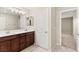Bathroom with a double sink vanity, dark wood cabinets, and a modern light fixture above the mirror at 2409 Bellinzona Pl, Henderson, NV 89044