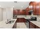 Well-lit kitchen features granite counters, stainless steel appliances and cherry wood cabinetry at 2409 Bellinzona Pl, Henderson, NV 89044