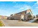 A street view featuring townhomes with desert landscaping, garages, and sidewalks at 2409 Bellinzona Pl, Henderson, NV 89044