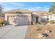 Charming single-story home featuring a two-car garage and a meticulously landscaped front yard with desert landscaping at 2444 Gamma Ray Pl, Henderson, NV 89044