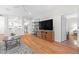 Open-concept living space with hardwood floors, a large TV, and seamless flow to the kitchen at 2444 Gamma Ray Pl, Henderson, NV 89044