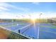 Outdoor tennis courts with blue and green surface areas enclosed with black fencing and overhead lighting at 2444 Gamma Ray Pl, Henderson, NV 89044