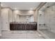 Elegant bathroom featuring double sink vanity with dark wood cabinets and large walk-in shower with marble tiling at 2583 Hazelburn Ave, Henderson, NV 89044