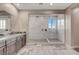 Sleek bathroom featuring an extra-large walk-in shower with marble tiling, and a double sink vanity at 2583 Hazelburn Ave, Henderson, NV 89044