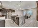 A spacious kitchen features granite counters, stainless appliances, and an island with seating and pendant lights at 2583 Hazelburn Ave, Henderson, NV 89044