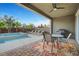 Covered patio featuring a dining table, a grill, and a jacuzzi surrounded by palm trees at 2583 Hazelburn Ave, Henderson, NV 89044