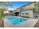 Backyard oasis featuring a sparkling pool, spa, covered patio, and lush landscaping for relaxation at 2583 Hazelburn Ave, Henderson, NV 89044