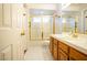 Bathroom with a glass-enclosed shower, light wood cabinets, and white tile flooring at 2611 S Durango Dr # 102, Las Vegas, NV 89117