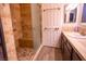 Bathroom with a glass-door shower, single vanity, and neutral finishes with wood-look floors at 2611 S Durango Dr # 102, Las Vegas, NV 89117