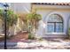 Exterior facade featuring an arched window and lush landscaping with a tiled walkway at 2611 S Durango Dr # 102, Las Vegas, NV 89117