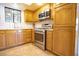 Cozy kitchen with stainless steel appliances, wooden cabinets, and tile backsplash at 2611 S Durango Dr # 102, Las Vegas, NV 89117