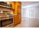 Kitchen with stainless steel oven and access to the dining room/ living room space with tile floors at 2611 S Durango Dr # 102, Las Vegas, NV 89117