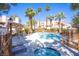 Community pool and spa area featuring mature palm trees, plenty of lounge chairs, and a covered dining area at 2611 S Durango Dr # 102, Las Vegas, NV 89117