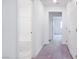 Hallway with white walls and doors leading to bathroom and bedroom with neutral color palette and carpeted floors at 3542 Arcadian King Ave, Las Vegas, NV 89106