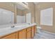 Bathroom features a double sink vanity, large mirror, and natural light from a window at 3544 Desert Cliff St # 102, Las Vegas, NV 89129
