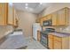 Well-lit kitchen with wooden cabinets, modern appliances, and gray wood-look flooring at 3544 Desert Cliff St # 102, Las Vegas, NV 89129
