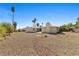 Large backyard with desert landscaping and a charming walkway leading to the home's rear entrance at 3568 Antigua Ave, Las Vegas, NV 89121
