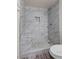 An updated shower features marble tile, river stone accents, and modern fixtures at 3568 Antigua Ave, Las Vegas, NV 89121