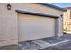 Beige garage door on a home with a brick driveway and exterior lighting at 3725 Celesta Vista Ave, Henderson, NV 89044