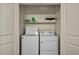 Functional laundry closet with white washer and dryer and storage shelf at 3725 Celesta Vista Ave, Henderson, NV 89044