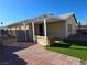 Backyard with a covered patio, artificial turf, and low-maintenance desert landscaping at 3836 Quail Creek Dr, North Las Vegas, NV 89032