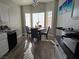 Bright dining area with a round table, large windows, and modern lighting fixture at 3836 Quail Creek Dr, North Las Vegas, NV 89032