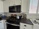 Bright kitchen featuring a black gas range, stainless steel appliances, and farmhouse sink at 3836 Quail Creek Dr, North Las Vegas, NV 89032