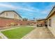 Enjoy this backyard with a covered patio, cozy seating, synthetic grass and desert landscaping at 422 Tanita Ct, Las Vegas, NV 89123