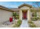 Close up of the front entrance showing a tiled roof, colorful desert landscaping and warm lighting at 422 Tanita Ct, Las Vegas, NV 89123