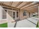 Covered back patio with access to home through sliding glass doors and artificial grass yard at 5000 Forest Oaks Dr, Las Vegas, NV 89149