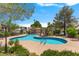 A community pool surrounded by lounge chairs and lush greenery at 5000 Forest Oaks Dr, Las Vegas, NV 89149
