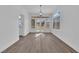 Dining room features gray wood-look floors, modern chandelier, and views of the backyard at 5000 Forest Oaks Dr, Las Vegas, NV 89149