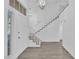 Bright, open foyer featuring gray wood-look floors, white walls, and a staircase at 5000 Forest Oaks Dr, Las Vegas, NV 89149