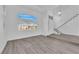 Bright, open living area with gray wood-look flooring, a staircase, and large windows at 5000 Forest Oaks Dr, Las Vegas, NV 89149