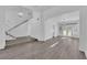 Bright open-concept living room featuring gray wood-look flooring, white walls, and a modern chandelier at 5000 Forest Oaks Dr, Las Vegas, NV 89149