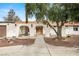 Close up of the front entrance highlighting desert landscaping, an arched entryway, and a tile roof at 5248 W Lake Mead Blvd, Las Vegas, NV 89108