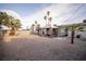 Expansive backyard featuring gravel, palm trees, and a covered patio area at 5408 Longridge Ave, Las Vegas, NV 89146