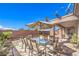 Charming backyard patio with comfortable outdoor dining setup and manicured landscaping at 5525 Criollo Dr, Las Vegas, NV 89122