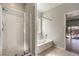 Bathroom featuring tile flooring, separate shower, soaking tub, and backyard access at 5525 Criollo Dr, Las Vegas, NV 89122