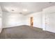 Spacious living room featuring neutral carpet, white walls, and doorway to bathroom at 5525 Criollo Dr, Las Vegas, NV 89122