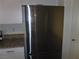 Stainless steel refrigerator complementing the white cabinets and granite countertops at 5642 Sunset Amber Ave, Las Vegas, NV 89122