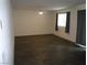 Empty living room featuring dark wood floors, two windows, a ceiling fan and neutral walls at 5642 Sunset Amber Ave, Las Vegas, NV 89122