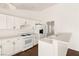 Bright kitchen showcases white cabinets, white appliances and countertops, and dark wood-look flooring at 6209 Lenaking Ave, Las Vegas, NV 89122