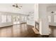 Living room flows into kitchen featuring hardwood floors, a fireplace, and large windows at 6209 Lenaking Ave, Las Vegas, NV 89122