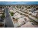 Aerial view showcases rooftops in neighborhood, mature trees, and desert landscape at 6276 Back Woods Rd, Las Vegas, NV 89142