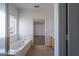 Bright bathroom with a white bathtub and a window letting in natural light at 6276 Back Woods Rd, Las Vegas, NV 89142