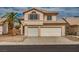 Two-story home boasts a three-car garage and a desert landscape, complete with a palm tree at 6276 Back Woods Rd, Las Vegas, NV 89142
