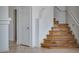 A view of the hardwood stairs in the entry way, with tiled floors and white walls at 6276 Back Woods Rd, Las Vegas, NV 89142