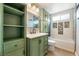 Charming bathroom features sage vanity and tub with decorative tile accents at 6858 Groveview Ln, Las Vegas, NV 89103