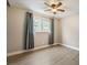 Unstaged bedroom with wood-look flooring, ceiling fan, window and curtains at 6858 Groveview Ln, Las Vegas, NV 89103